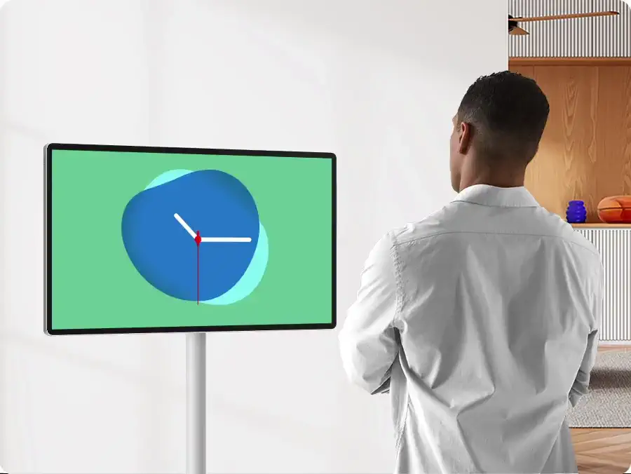 Ekranda saat widget’ı gösteren The Movingstyle’a bakan bir kişi